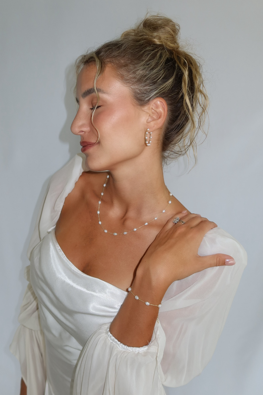 Bride wearing WAAWEES water-resistant gold necklace with pearl pendant, styled for wedding day.
